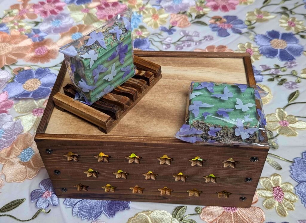 Two Patchouli Artisan Bar Soaps in wrappers resting on Rectangular Soap Tray